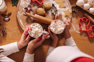 Kış içkisinin en üst görüntüsü, beyaz kazaklı kadın ellerinde lokum olan beyaz kupa. Ev yapımı fırın, geleneksel festival tatlısı pişirmek. Tahta masada zencefilli ekmek hamuru. Yeni yıl kutlaması