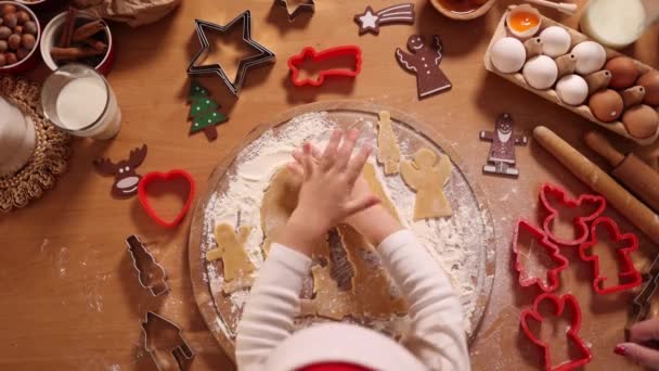 Membuat roti jahe di rumah. Gadis kecil memotong kue adonan roti jahe. Konsep tradisi Natal dan Tahun Baru. Toko roti Natal. Selamat berlibur. Tampilan atas — Stok Video