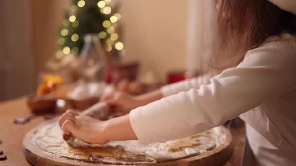 Fille et maman utilisant rouleau à pâtisserie pour faire du pain d'épice. Vue du dessus de la pâte crue roulante pour le pain d'épice. L'humeur de Noël. Je me prépare pour les vacances. Vue latérale — Video