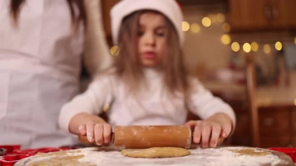 Filha e mãe usando rolo para fazer pão de gengibre. Vista superior da massa crua rolando para pão de gengibre. Humor de Natal. Preparação para férias — Vídeo de Stock