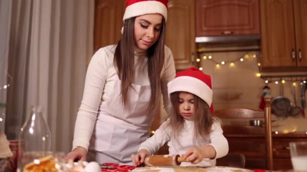 Fille et maman utilisant rouleau à pâtisserie pour faire du pain d'épice. Vue du dessus de la pâte crue roulante pour le pain d'épice. L'humeur de Noël. Se préparer pour les vacances — Video