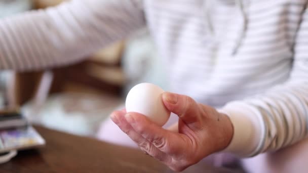 한 여인 이 부활절 달걀 축제를 위해 환상의 계란에 물감을칠 하고 있다. 암컷 이 작은 노란 병아리를 그린다. 봄의 상징. 부활절 개념. 비디오 60fps — 비디오