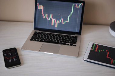 Çevrimiçi ticaret yaparak para kazanıyorum. Monitör için bilgisayar, tablet ve telefon kripto para birimini arttırıyor. Konut kredisi, yatırım, ekonomi, tasarruf parası veya sigorta kavramı