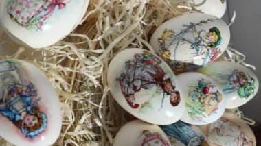 Paskalya festivali için kaz yumurtalarının üzerine bir sürü farklı çizim. Saman üstünde yumurta. El yapımı parmak izi. Bahar tatilleri. Paskalya konsepti. Dikey video 50fps