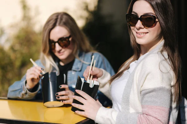 Leckeres Mittagessen mit asiatischem Essen zum Mitnehmen im Freien. Beste Freunde verbringen Zeit zusammen im prall sonnigen Tag — Stockfoto