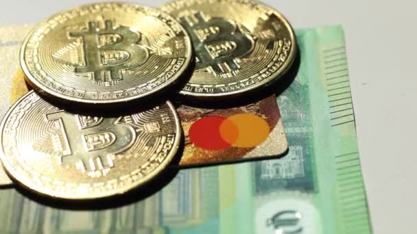 Bitcoins dorés placent sur les cartes de crédit sous les billets en euros. Concept de crypto-monnaie. Ferme là. Vidéo 4K 50 images par seconde — Video