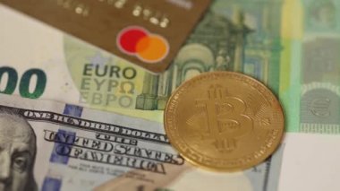 Altın bitcoin 'ler Amerikan doları ve euro banknotlarının altında kredi kartlarında yer alıyor. Kripto para birimi konsepti. Kapat.