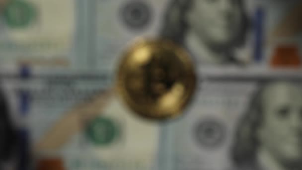 Rozostřené video zlatých lesklých bitcoinových mincí na sto amerických dolarových bankovkách. Rozdíl mezi kryptoměny a hotovostí — Stock video