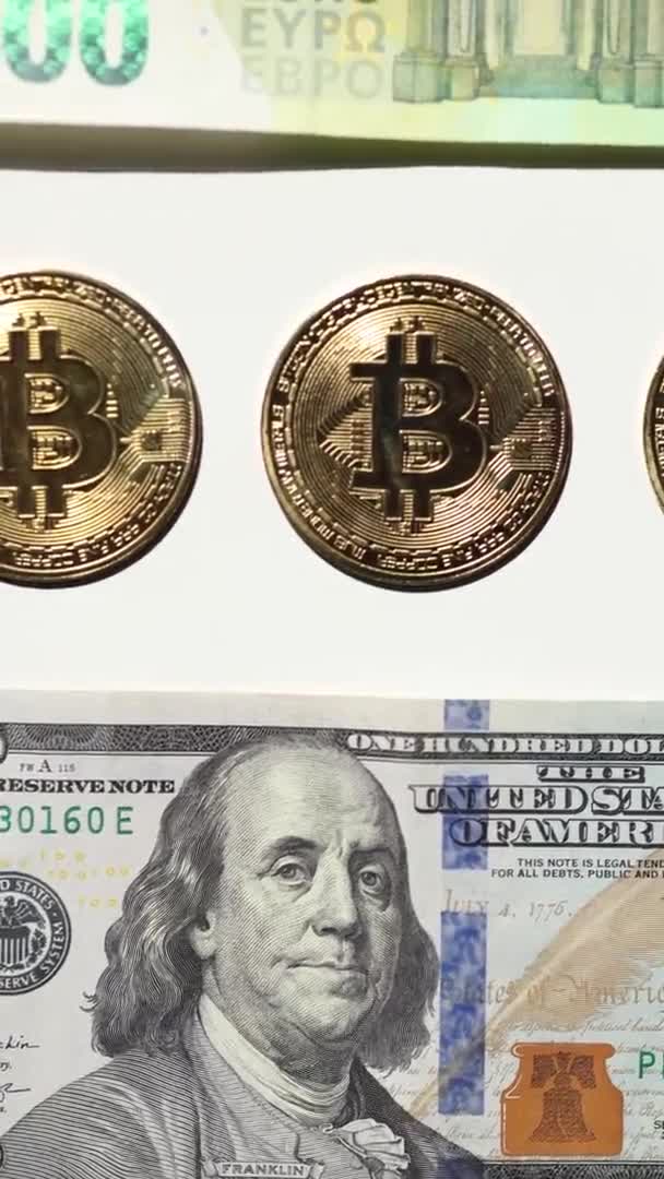 Digitala kryptovaluta guld bitcoin ligger mellan US Dollar och eurosedlar. Skillnaden mellan virtuella pengar och kontanter. Begreppet nya virtuella pengar. Vertikal video — Stockvideo