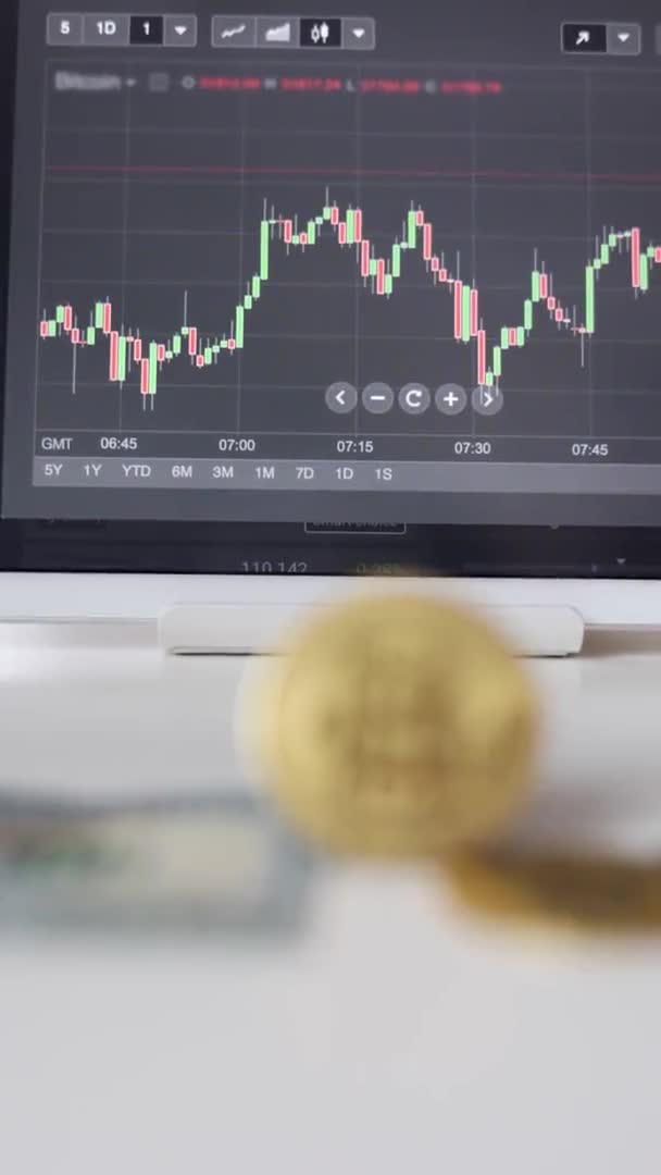 Oskärpa video av guld bitcoin crypto valuta på bakgrund av tablett med lager diagram. Investeringar i virtuella pengar. Cryptocurrency koncept — Stockvideo