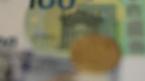 Goldene Bitcoins werden auf Kreditkarten unter Dollar- und Euro-Banknoten platziert. Kryptowährungskonzept. Aus nächster Nähe. Defokussiertes Video — Stockvideo