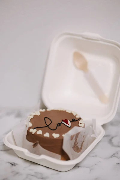 Bolo Bento com inscrição amor e corações de açúcar branco em embalagem eco-box com colher de madeira. Bolo de chocolate — Fotografia de Stock