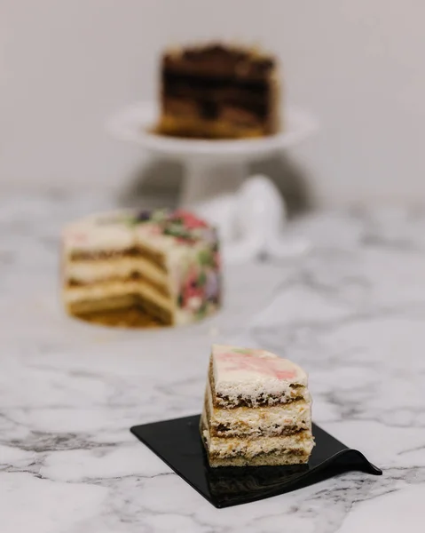 Slice of tiramisu bento cake. Presentation of cake in section. Sweet dessert for one person. Little birthday cake. Background of others bento cake — Stock Photo, Image