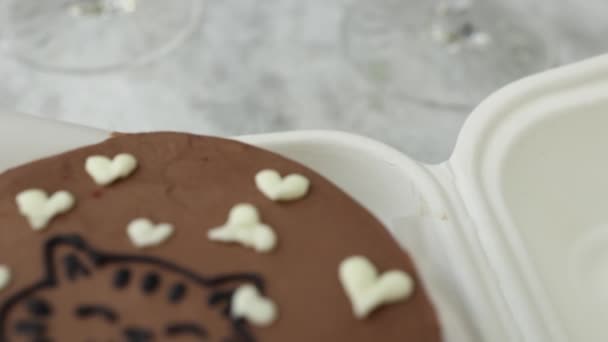 Close-up van bento cake met schattige foto van katten- en witte suikerhartjes in eco box-verpakking met houten lepel. Chocoladetaart — Stockvideo