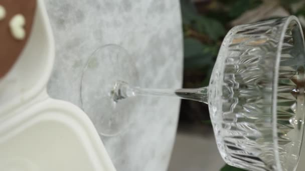 Schokoladenbento-Kuchen mit weißer Kerze und Chmpagne-Gläsern auf einem luxuriösen Marmortisch. Vertikales Video — Stockvideo