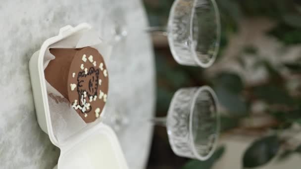 Chocolade Bento cake met witte kaars en chmpagne glazen op luxe marmeren tafel. Verticale video — Stockvideo