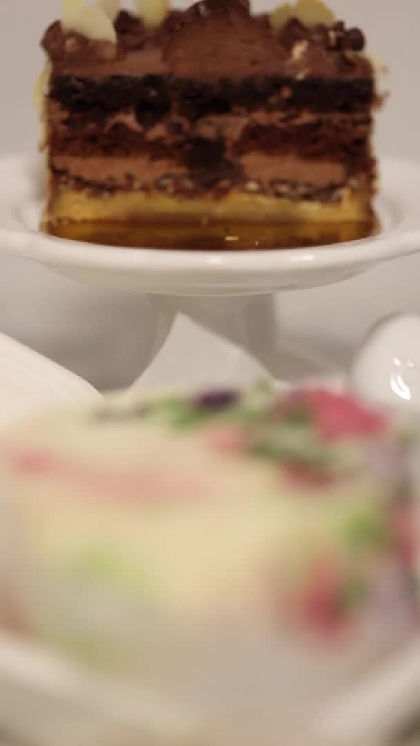 Три разных пирога на белом столе. Маленький торт на одного человека в подарок на праздник. Вертикальное 4K видео 50 кадров в секунду — стоковое видео