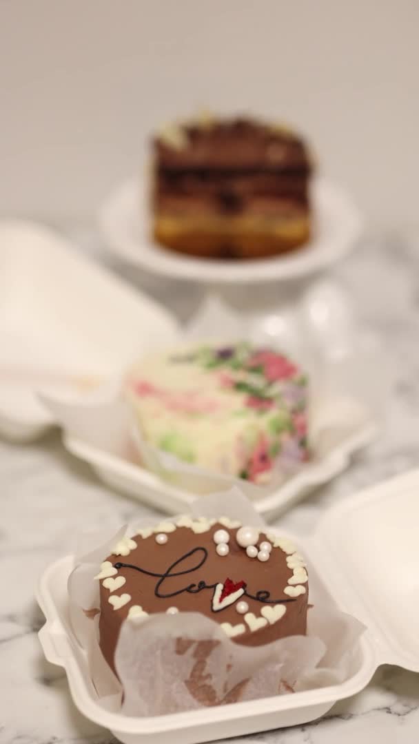 Три разных пирога на белом столе. Маленький торт на одного человека в подарок на праздник. Вертикальное 4K видео 50 кадров в секунду — стоковое видео