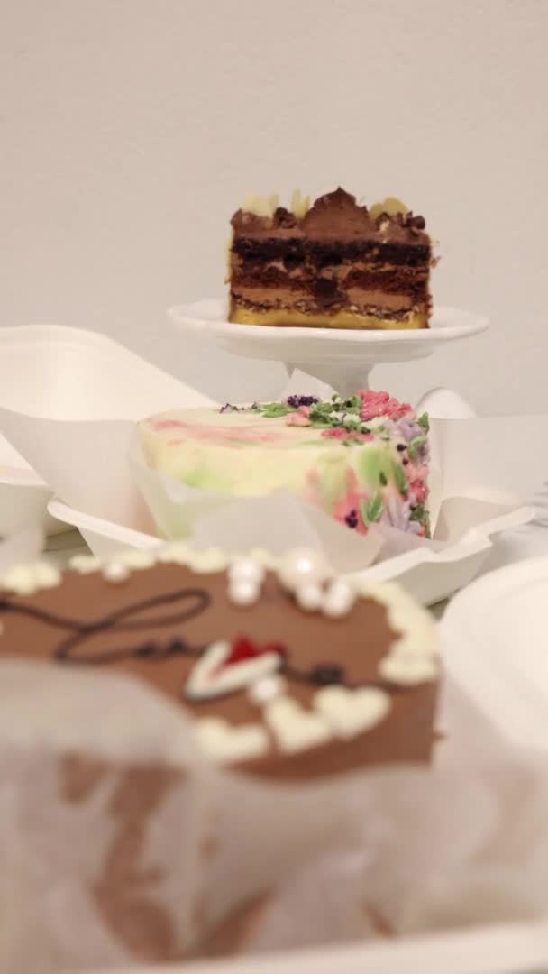 白いテーブルの上に3種類のお弁当ケーキ。休日の贈り物として一人用の小さなお弁当ケーキ。垂直4Kビデオ50fps — ストック動画
