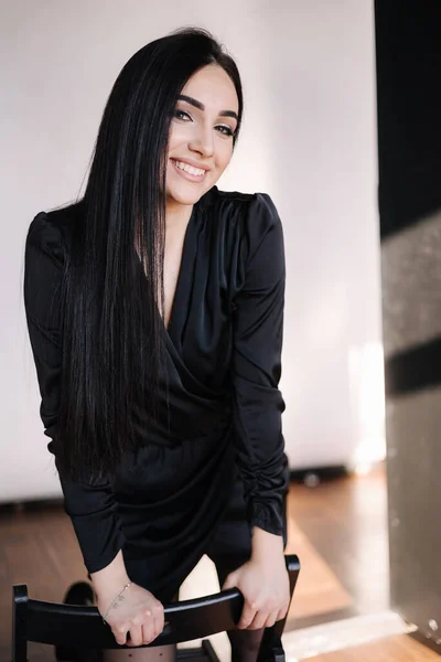 Mooie brunette in elegante zwarte jurk. Vrouw met avondmake-up. Studio fotoshoot — Stockfoto