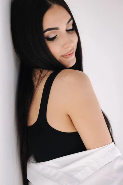 Portret van een mooie vrouw in de studio. Mooi brunette meisje in zwart onderwerp. Witte achtergrond van cyclorama — Stockfoto