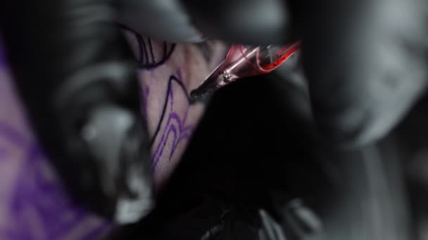 Close up of tattoo master making black tattoo with paint. Master works in black sterile gloves. Young tattoo artist in work. Wireless tattoo machine. 4K vertical video — Video