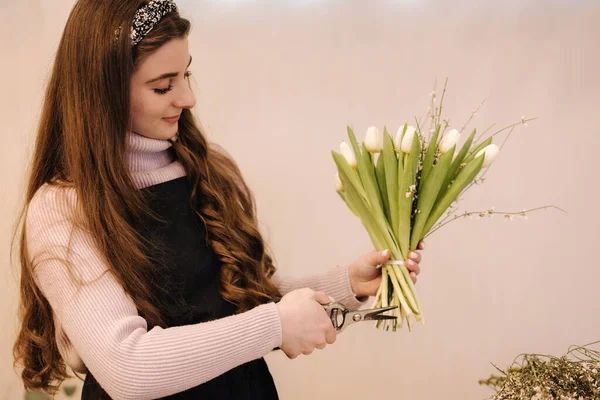 Молода жінка відрізає кінцівки квітів — стокове фото