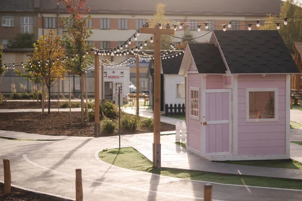 Mini şehir eğlence için. Çocuklar için oyuncak şehri. Küçük kulübeler, trafik işaretli yollar, sokak lambaları, çocuk parkı.