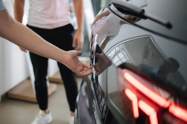 Närbild av olika element bil exteriör design. Bakåt på bilen. Man öppnar bakluckan — Stockfoto