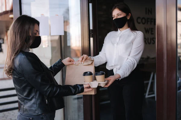 年轻女子戴着面具站在户外 在咖啡店用Nfc技术通过智能手机支付账单 女性客户使用非接触式技术支付费用 女人服从命令 把食物拿走 — 图库照片
