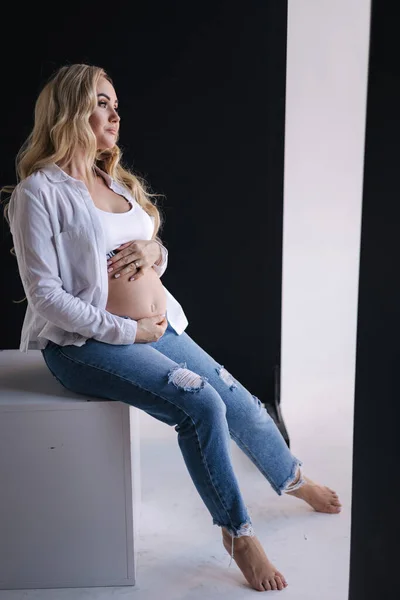 Těhotná Žena Sedí Bílé Kostce Položí Ruce Břicho Denim Styl — Stock fotografie