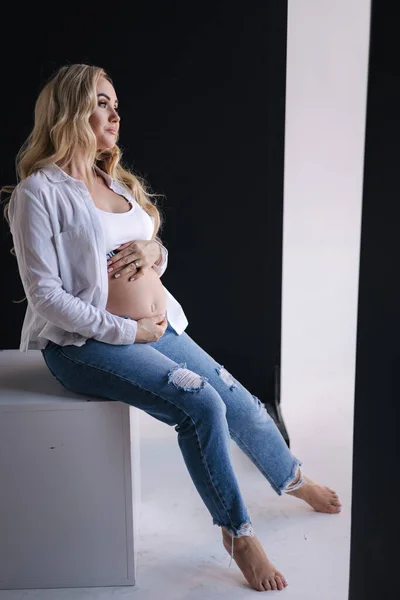 Mulher Grávida Senta Cubo Branco Umas Mãos Postas Barriga Estilo — Fotografia de Stock