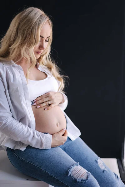 Mujer Embarazada Sienta Cubo Blanco Pone Las Manos Vientre Estilo — Foto de Stock