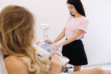 Güzel bir model lazer ışığı çıkarmadan önce koruyucu gözlük takar. Kozmetik salonunda tüysüz pürüzsüz cilt tedavisi. Birinci kişi görünümü.