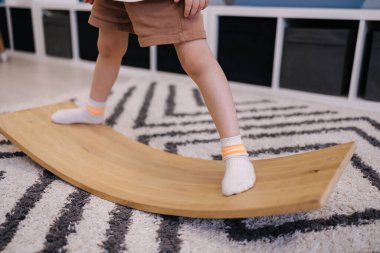 Tahtada dengede duran bir çocuk, vestibüler aparatın trainig 'i. Yakın plan.