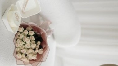 Sürpriz parti için evde dekore edilmiş bir oda. Kanepede bir buket çiçek ve banto pastası. Birkaç renkli balon. 18 yaşındaki bir kızın doğum günü kutlu olsun. Dikey video.