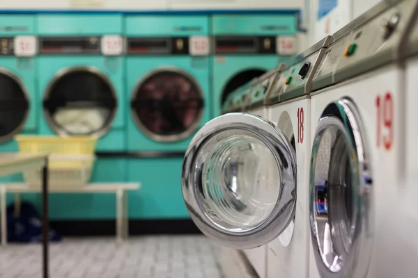 rij van wasing machine en kleren drogers - wasserette