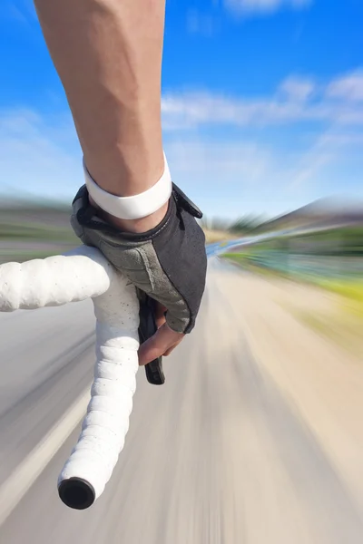 Close up of road bike rider with motion blurred roadway — Stock Photo, Image