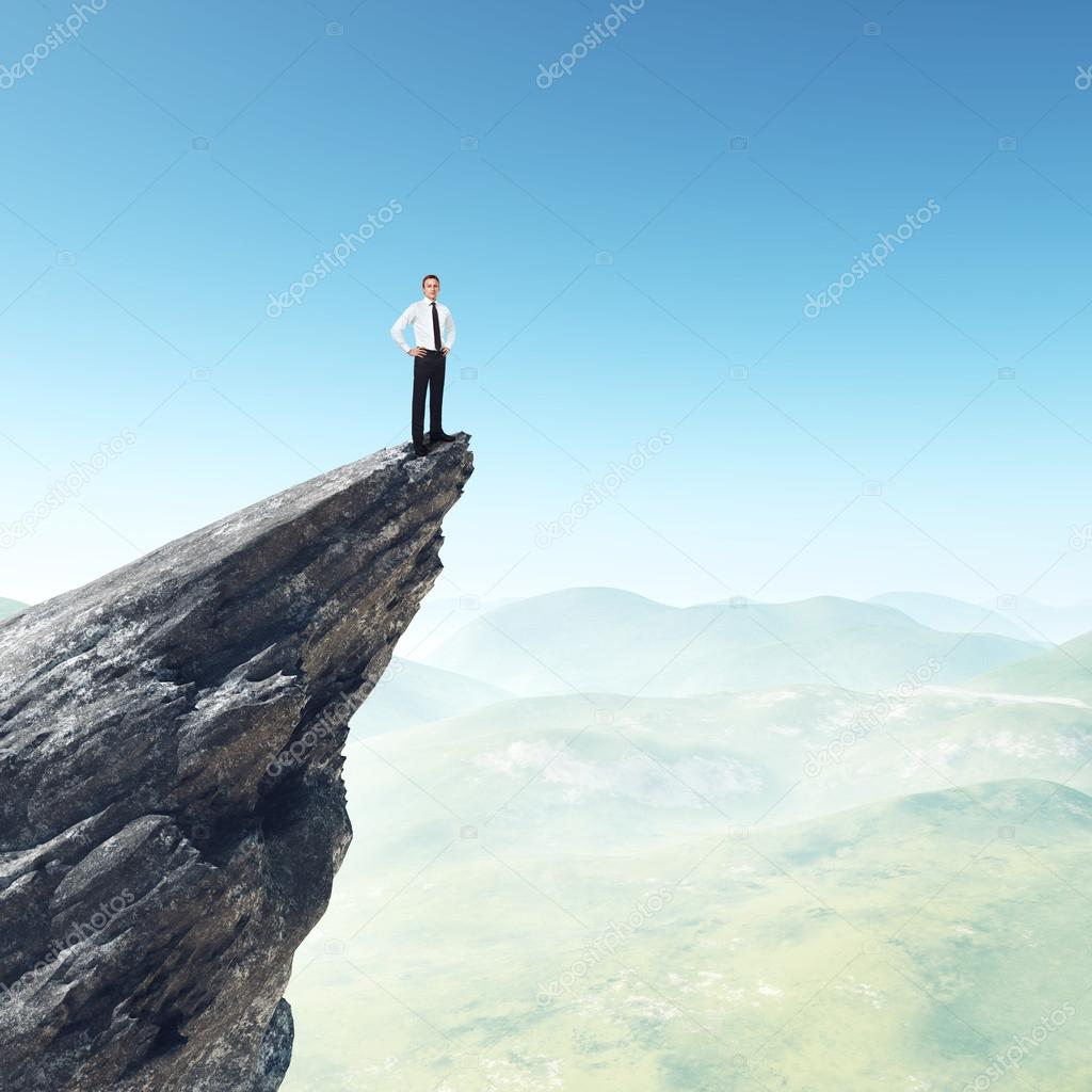 Businessman standing on a peak