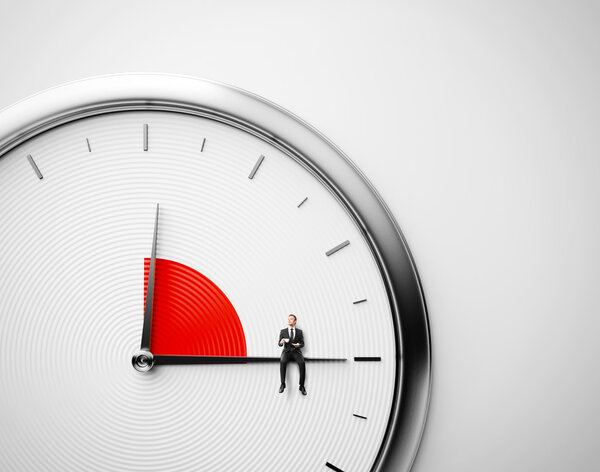 Часы и бизнесмен сидят на минутной руке с чашкой кофе. Концепция обеда
.