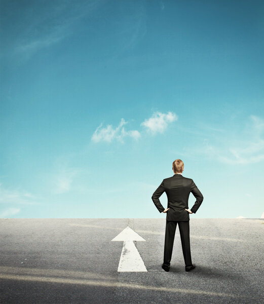 Background with businessman looking forward in desert and arrow