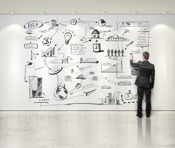 Man drawing strategy on white wall — Stock Photo, Image