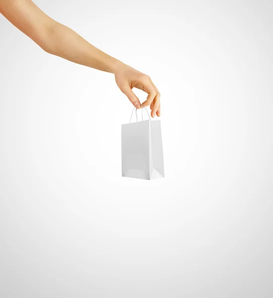 Hand holding little white gift bag isolated on white — Stock Photo, Image