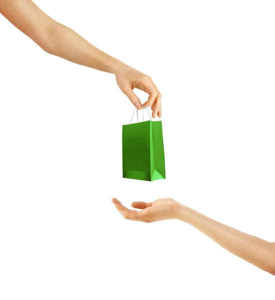Hand giving little green paper bag. Isolated on white — Stock Photo, Image