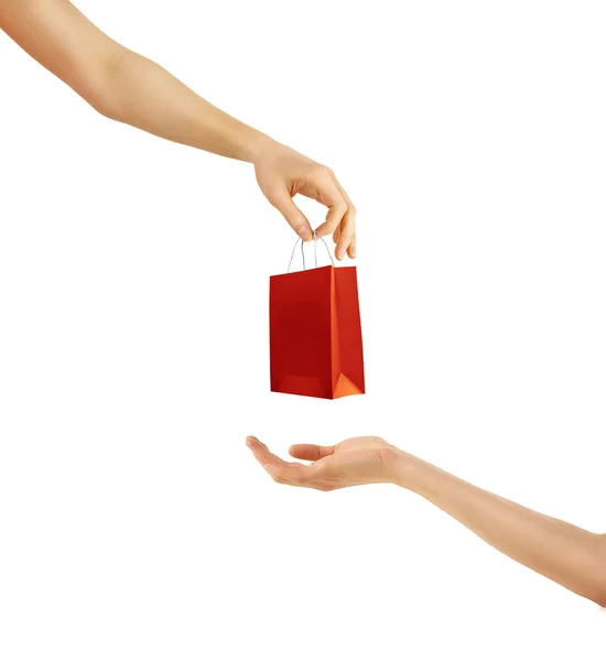 Mano dando pequeña bolsa de papel. Aislado sobre blanco —  Fotos de Stock