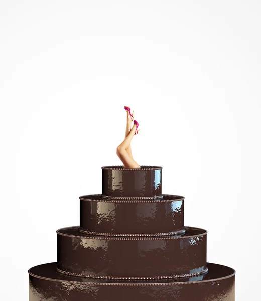 Female legs stick out from a large chocolate cake — Stock Photo, Image