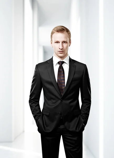 Businessman standing in bright office — Stock Photo, Image