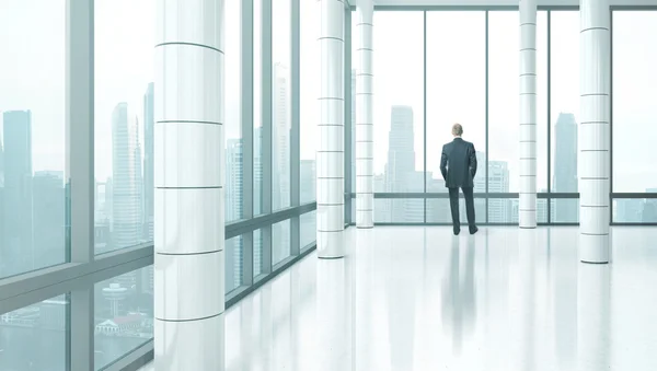 Geschäftsmann steht im hellen Büro — Stockfoto