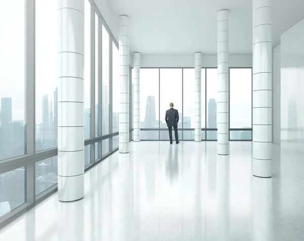 Бизнесмен, стоящий в светлом офисе — стоковое фото