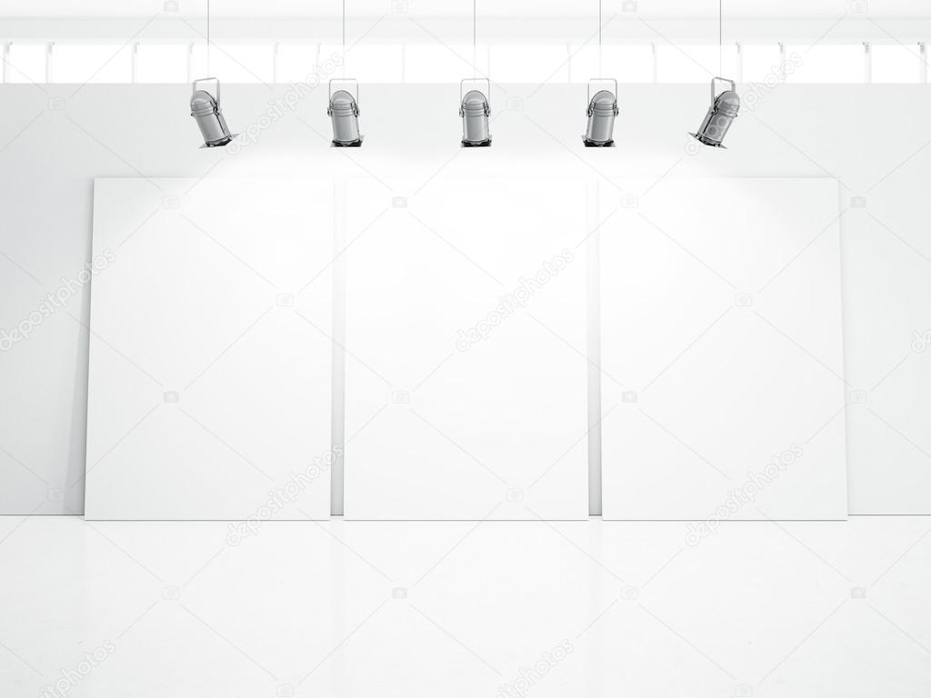 Three blank posters on white wall